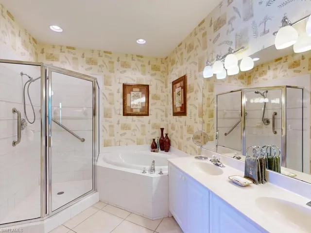 Bathroom featuring independent shower and bath, vanity, and tile patterned floors