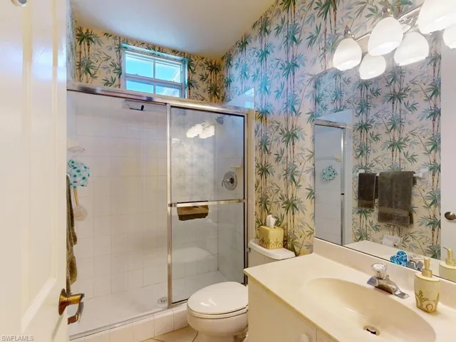 Bathroom with vanity, toilet, and an enclosed shower