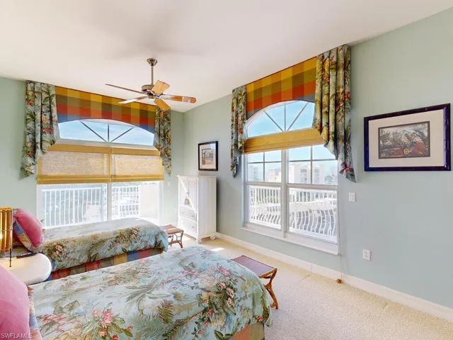 Bedroom featuring multiple windows, carpet floors, and ceiling fan