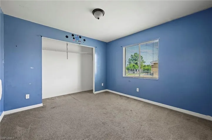 Unfurnished bedroom featuring carpet flooring and a closet
