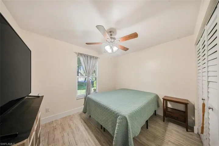 Bedroom with light wood-type flooring, a ceiling fan, and a closet