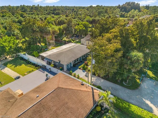 Aerial view of property and surrounding area with a forest