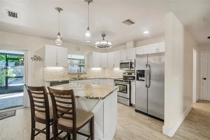 Kitchen featuring stainless steel appliances, backsplash, light wood-type flooring, and recessed lighting
