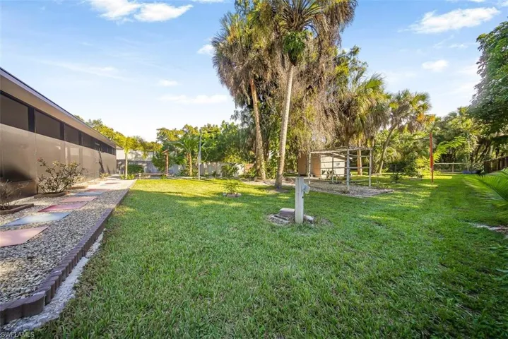 Fenced backyard featuring a sunroom