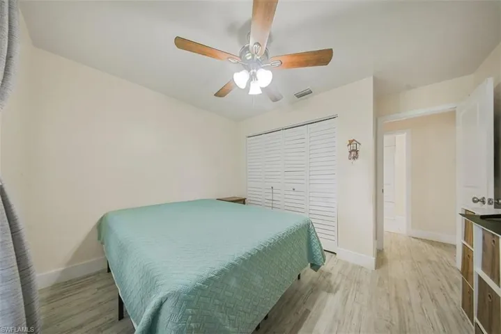 Bedroom with light wood finished floors, a ceiling fan, and a closet