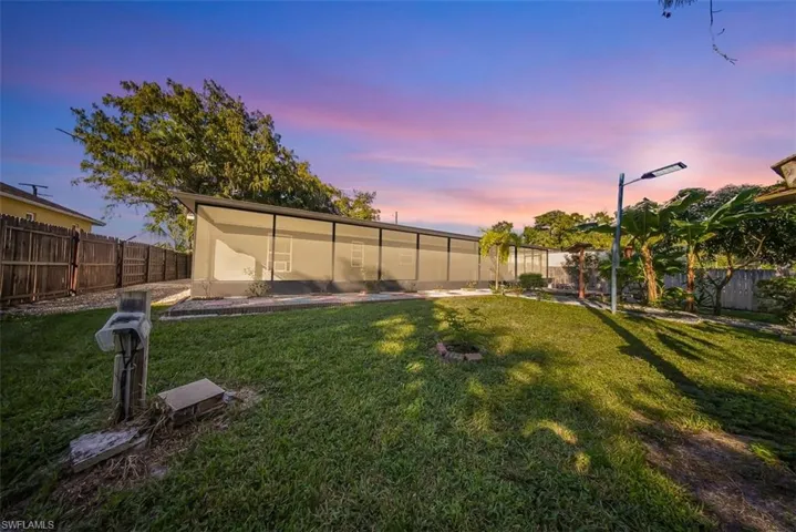 Yard at dusk featuring a fenced backyard