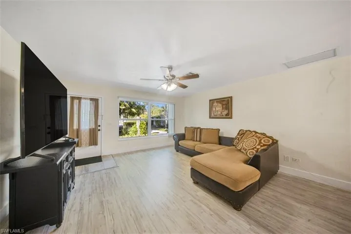 Living room with light wood-type flooring and a ceiling fan
