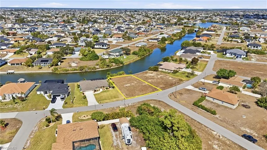Aerial view of property and surrounding area with nearby suburban area and a nearby body of water