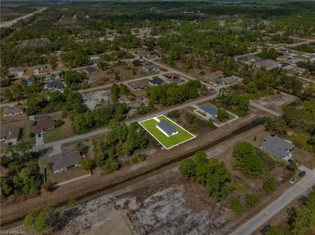 Aerial view of property's location with nearby suburban area