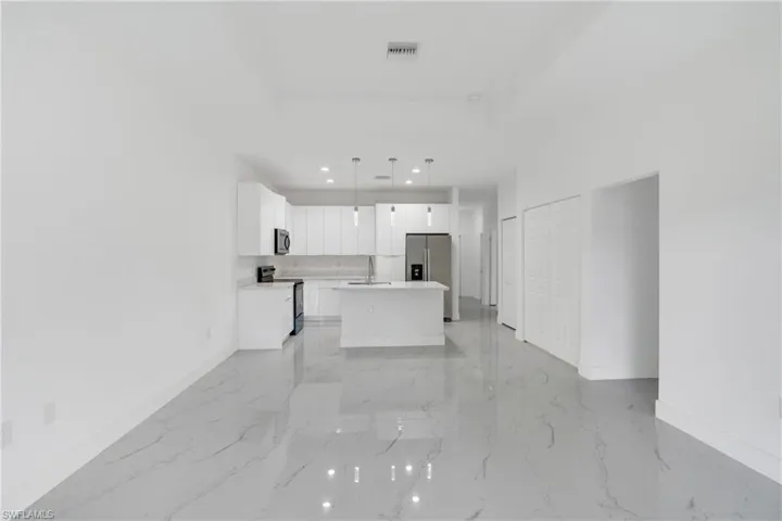 Unfurnished living room featuring baseboards and recessed lighting