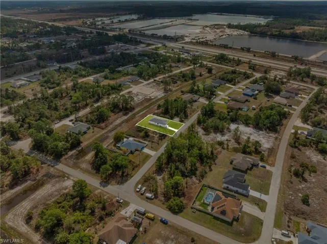 Aerial overview of property's location with a large body of water and nearby suburban area