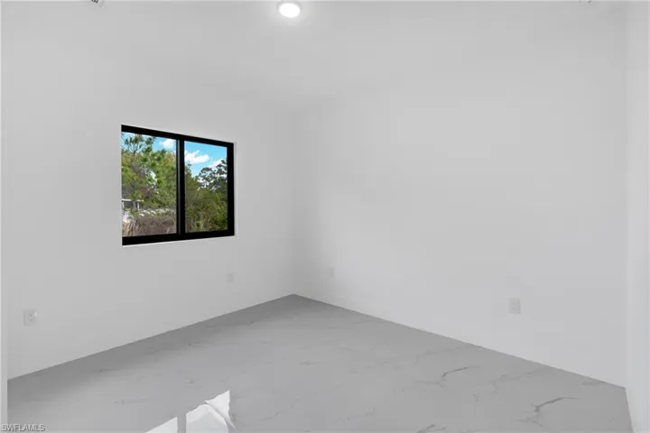 Spare room with light marble finish floors and baseboards
