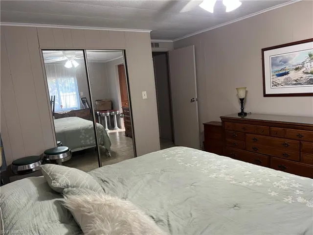Bedroom with a closet, visible vents, and ornamental molding
