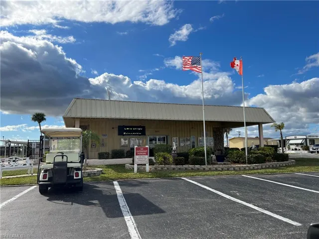 View of clubhouse building exterior next to one of the pools