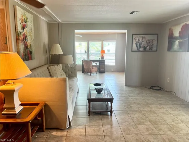 Tiled living area with ornamental molding and wooden walls