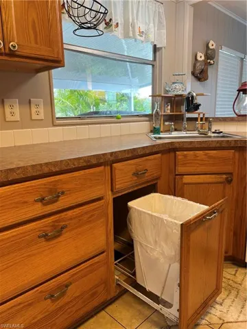 Kitchen featuring a sink, brown cabinets, plenty of natural light, and dark countertops
