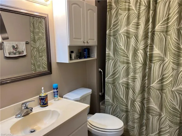 Bathroom with vanity and toilet, tub and shower combo