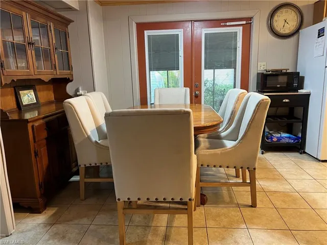 Dining space featuring light tile patterned flooring and french doors