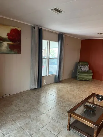 Living room with ornamental molding and tile patterned flooring