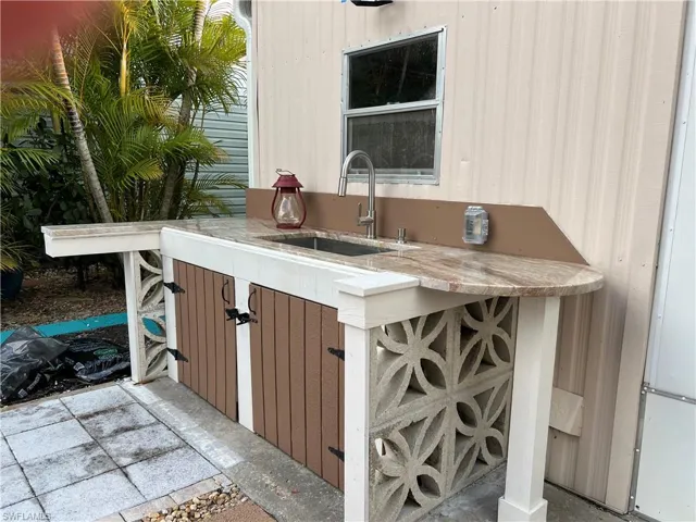 View of patio, with partial outdoor kitchen terrace with granite bar and a sink