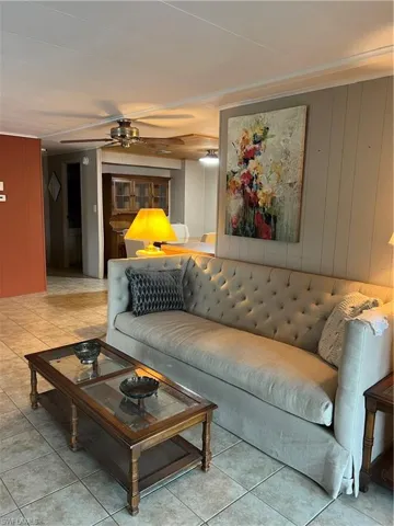Living room with ceiling fan and tile patterned flooring