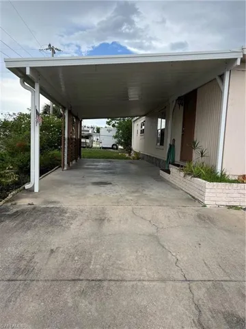 View of vehicle parking featuring driveway and an attached carport