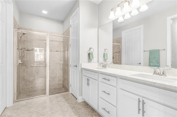 Bathroom with double vanity and a stall shower