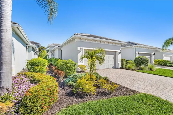 View of front of property featuring stucco siding, driveway, and an attached garage