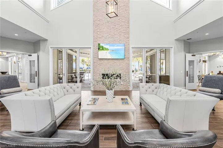 Living room with french doors, wood finished floors, healthy amount of natural light, and a high ceiling