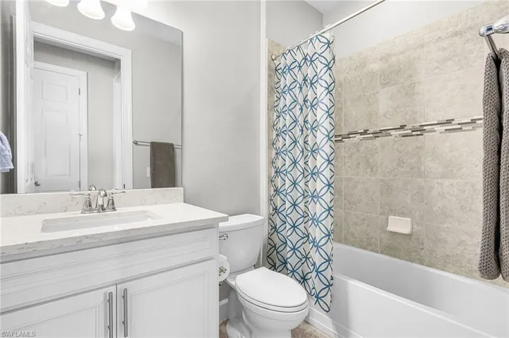 Bathroom with shower / tub combo with curtain and vanity