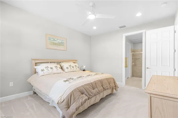 Bedroom with light carpet, a ceiling fan, connected bathroom, and recessed lighting