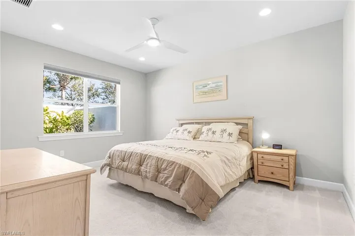 Bedroom with light carpet, a ceiling fan, and recessed lighting