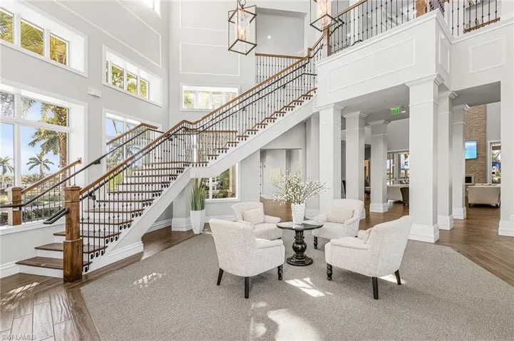 Living room featuring decorative columns, hardwood / wood-style floors, healthy amount of natural light, and a high ceiling