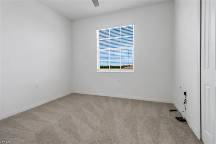 Room featuring neutral tone carpeting and white baseboards