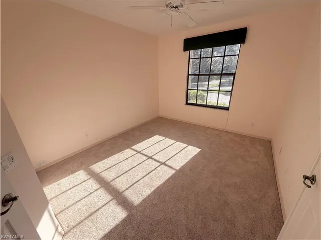 Spare room featuring light carpet and a ceiling fan