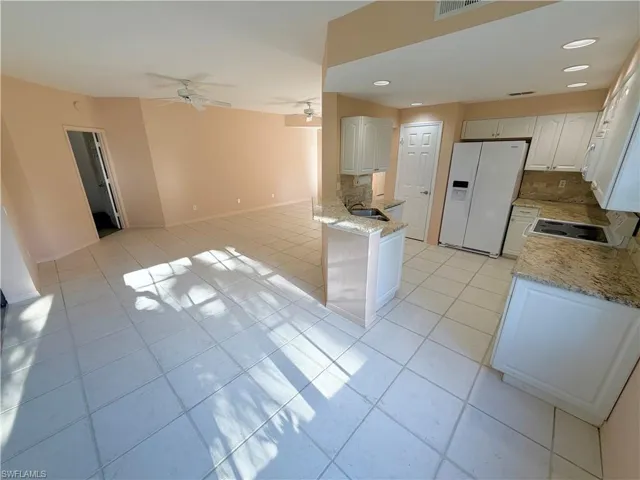 Kitchen featuring white appliances, light tile patterned floors, recessed lighting, white cabinetry, and ceiling fan
