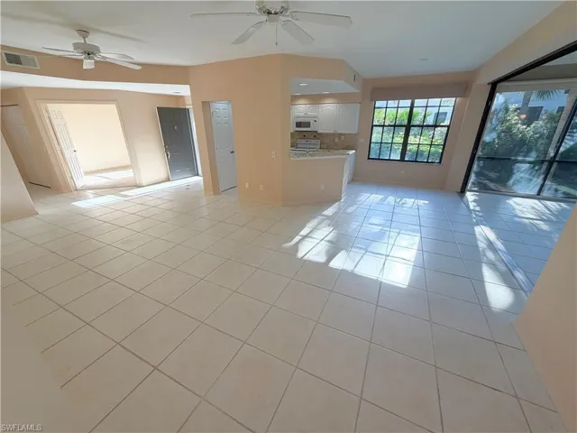 Unfurnished living room featuring a ceiling fan and light tile patterned floors