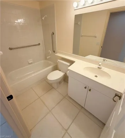 Full bath with vanity, light tile patterned flooring, and bathing tub / shower combination