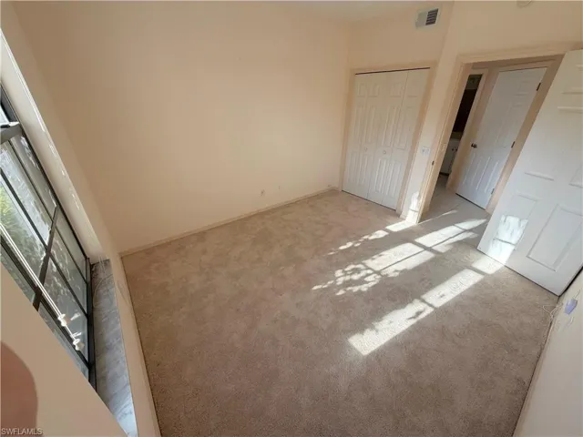 Unfurnished bedroom with a closet and light carpet