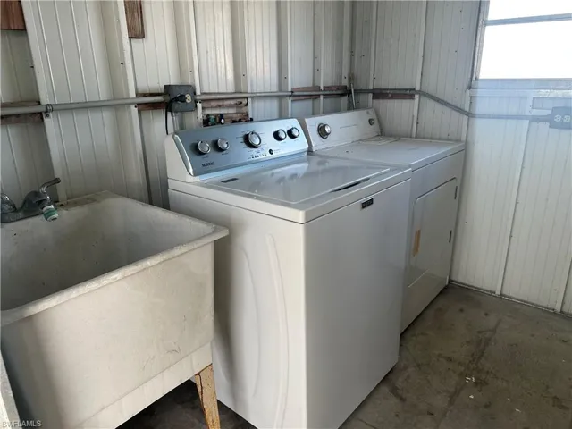 Laundry room featuring washing machine and clothes dryer and unfinished concrete floors