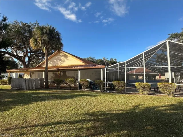 Back of house featuring a sunroom, a lawn, a lanai, and a patio