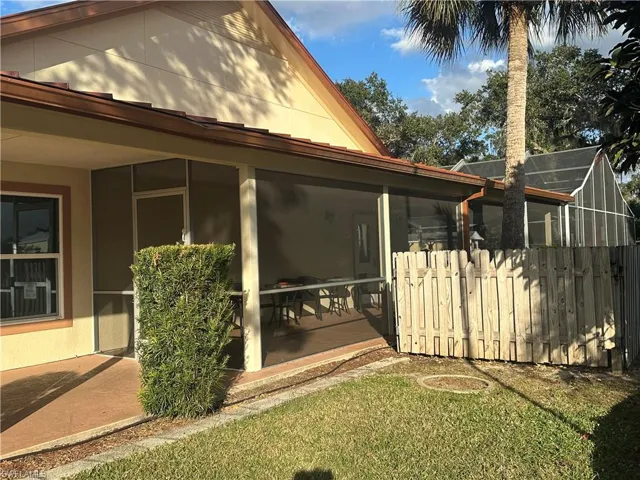 View of side of property featuring a sunroom and stucco siding