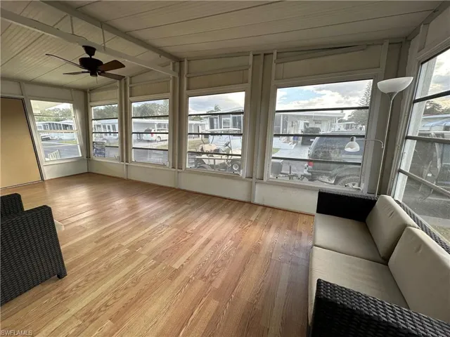 sunroom with vaulted ceiling, wood finished floors, and healthy amount of natural light