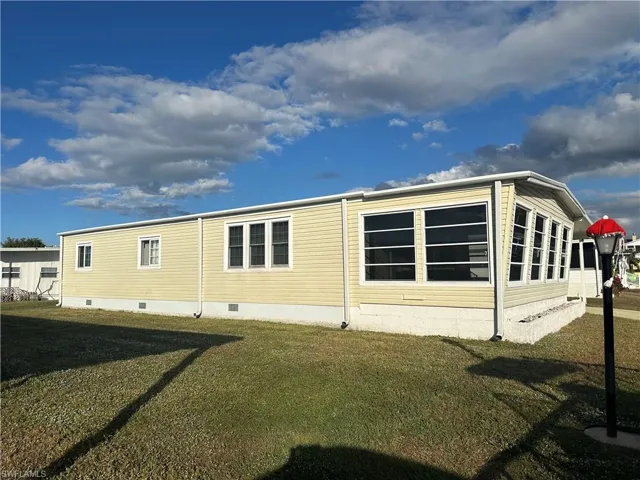Rear view of house featuring crawl space and a yard