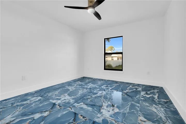 Spare room featuring baseboards and ceiling fan