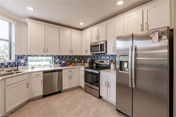 Kitchen featuring white cabinets, tasteful backsplash, and appliances with stainless steel finishes