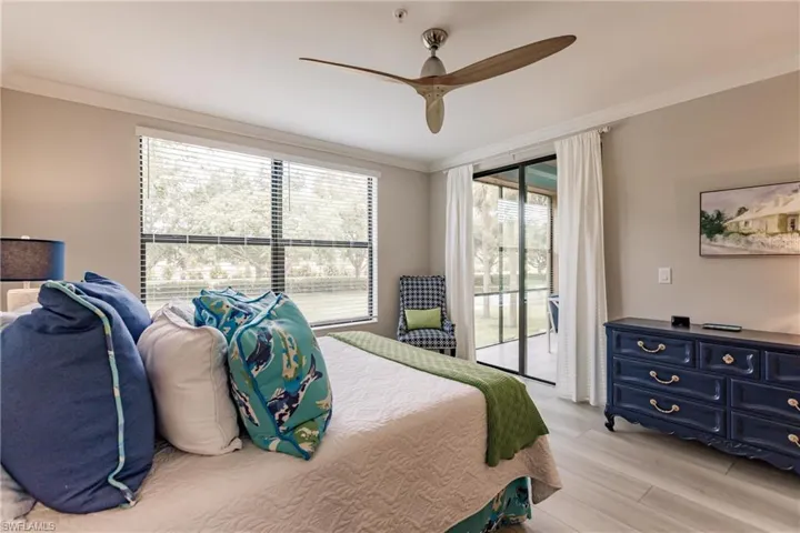 Bedroom featuring light hardwood / wood-style floors, multiple windows, access to outside, and ceiling fan