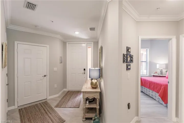 Hall featuring crown molding and light tile patterned floors