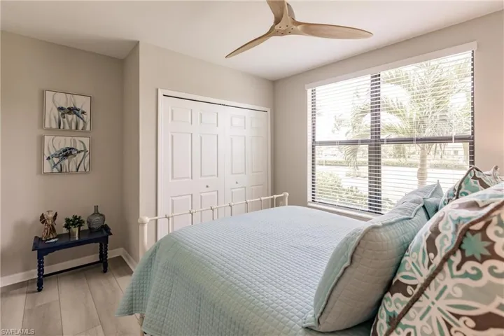 Bedroom with ceiling fan, multiple windows, light hardwood / wood-style flooring, and a closet