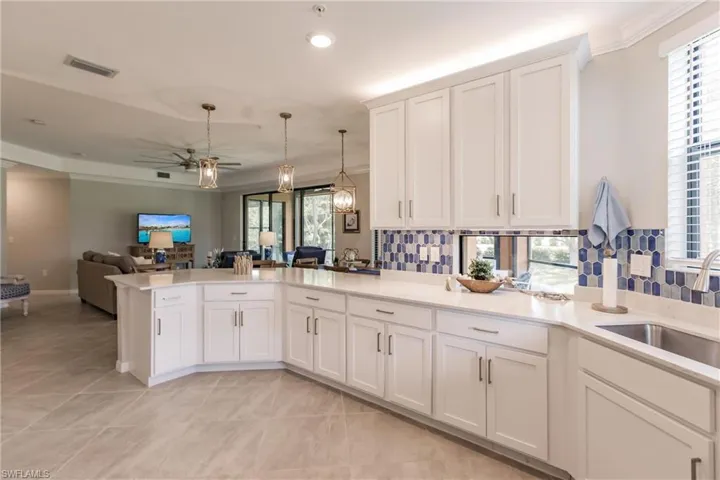 Kitchen featuring light tile patterned floors, tasteful backsplash, and kitchen peninsula